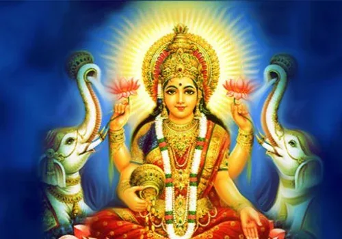 Goddess Lakshmi holding lotus flowers, seated between two white elephants raising their trunks, against a deep blue background