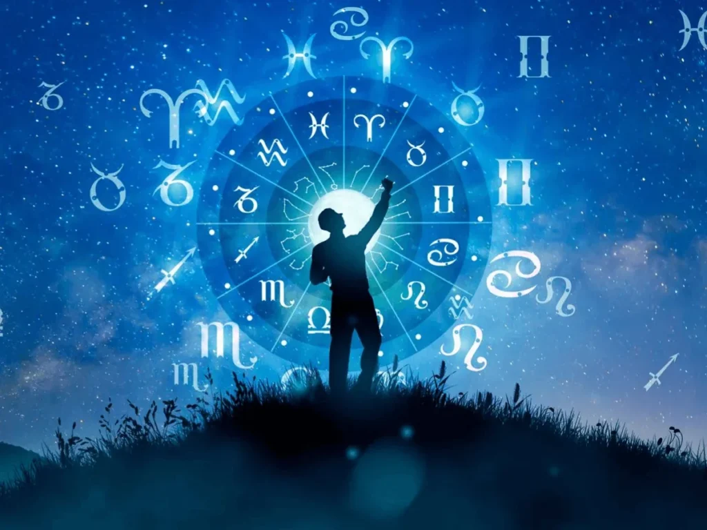Silhouette of a person reaching toward a glowing zodiac wheel under a starry blue night sky for past life astrology